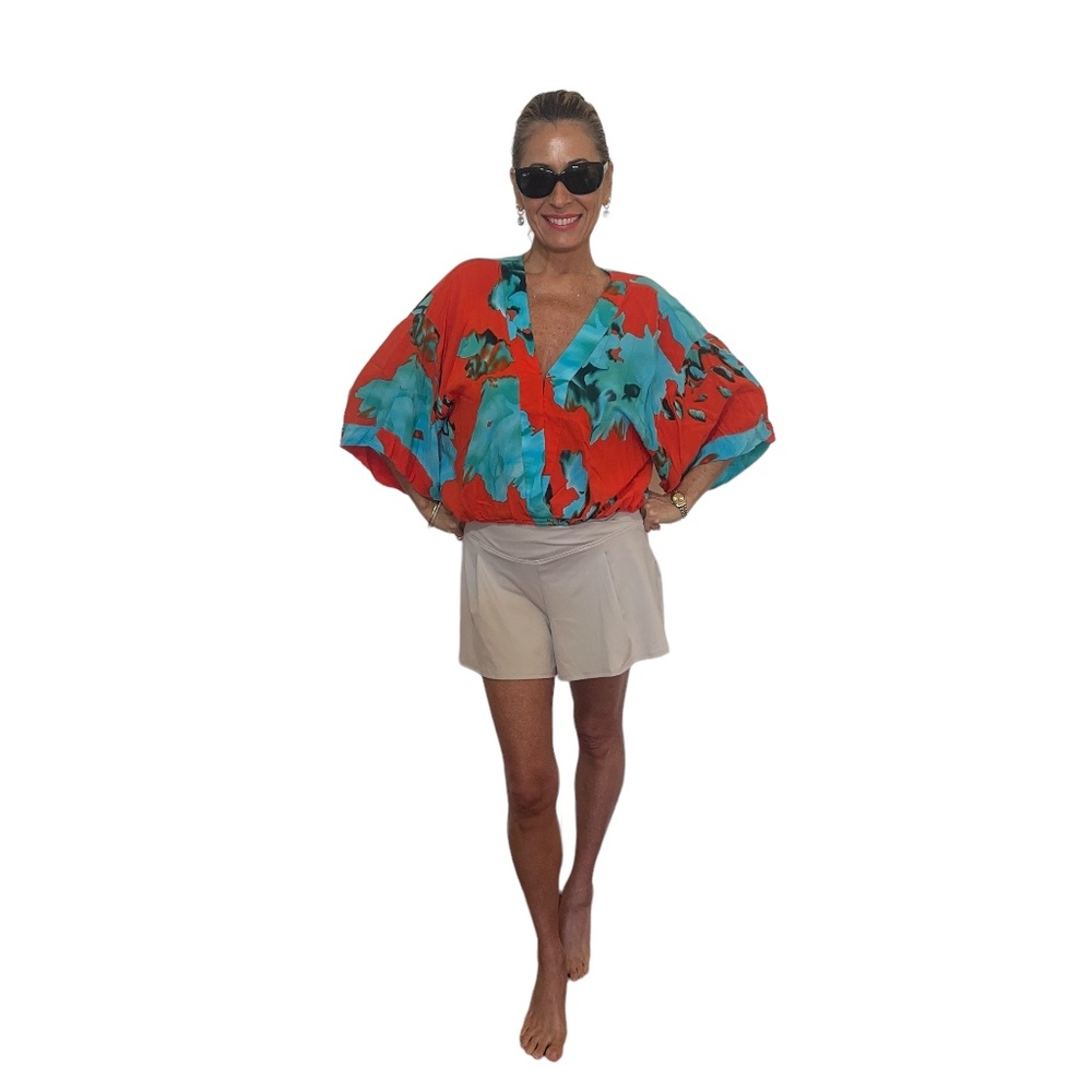 Red and turquoise women's top with elastic waist. V neck overlapping collar.